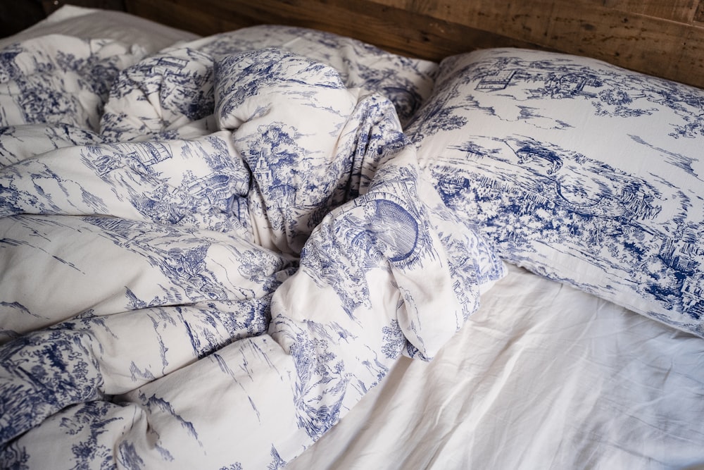 흰색 침대에 파란색과 흰색 베개