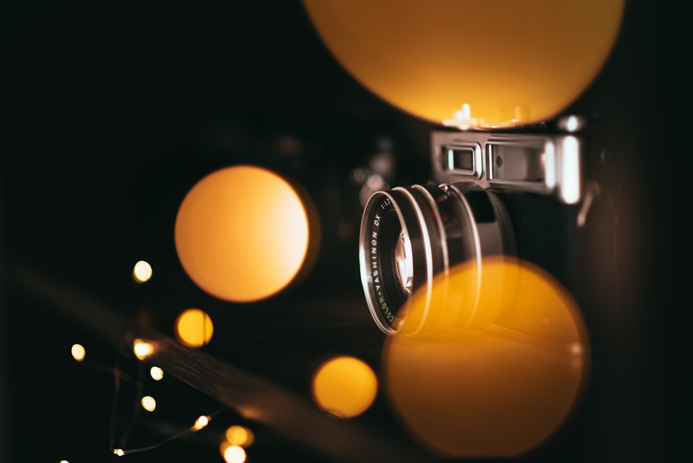 black and gray SLR camera with yellow bokeh light