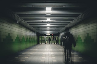 man walking on train subway by Aleksandar Savic (@aleksandarsavic)
