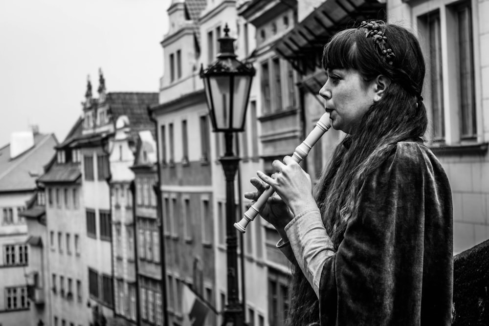 uma mulher em pé em uma rua segurando uma flauta