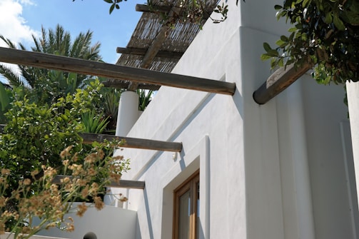 Minimalist beachfront villa with clean lines and palm trees swaying nearby.
