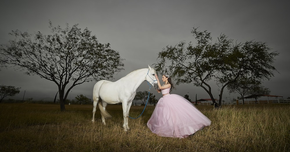 menina segurando a cabeça branca do cavalo