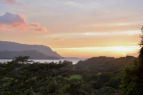 A scenic view of Santa Catarina’s lush green mountains and coastline at sunset.