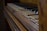 An old, worn-out piano with several broken and uneven keys. The wooden frame appears aged and slightly polished, hinting at a vintage or antique appearance. The focus is on the details of the keys and the texture of the wood.