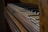 An old, worn-out piano with several broken and uneven keys. The wooden frame appears aged and slightly polished, hinting at a vintage or antique appearance. The focus is on the details of the keys and the texture of the wood.