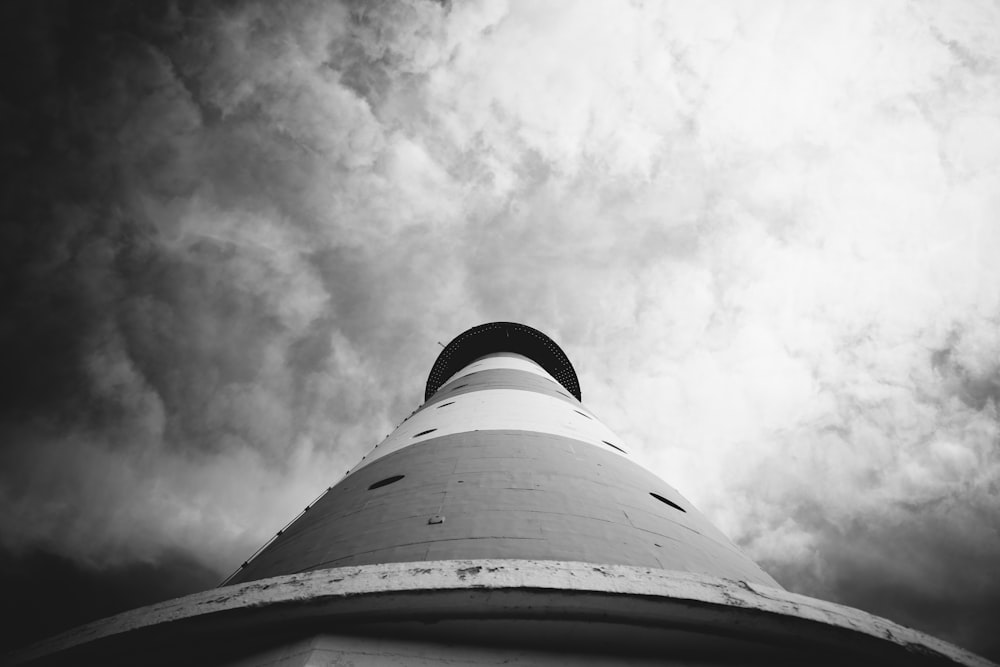 greyscale and low angle photography of lighthouse