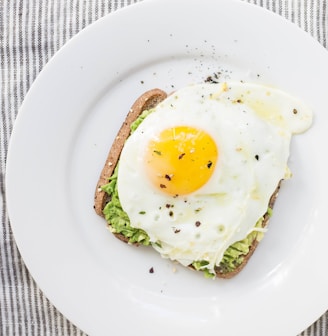 sunny side up egg, lettuce, bread on white ceramic plate