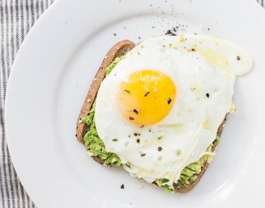 sunny side up egg, lettuce, bread on white ceramic plate