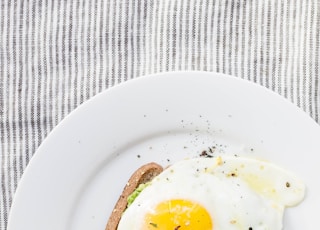 sunny side up egg, lettuce, bread on white ceramic plate