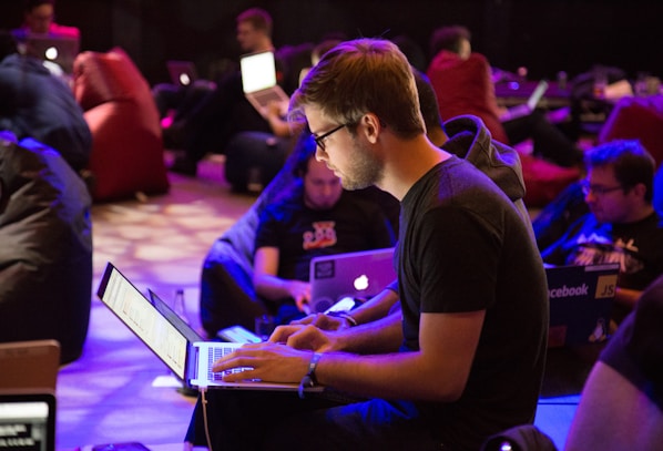 man using laptop in front of brown chair