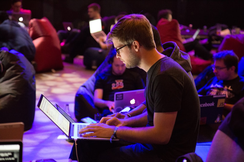 man using laptop in front of brown chair