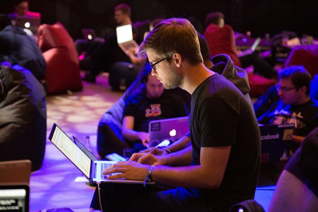 Developer coding on a laptop at a lit event