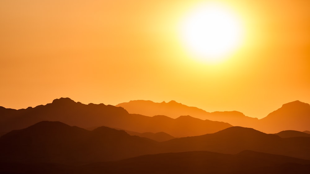 silhueta das montanhas sob o céu alaranjado