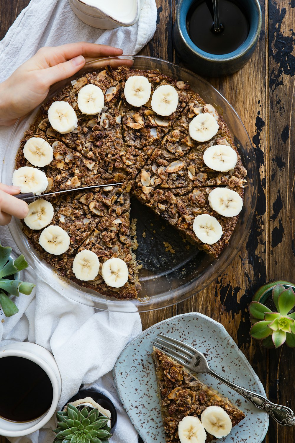 person slicing chocolate banana cake