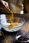 person pouring seasonings on clear glass bowl