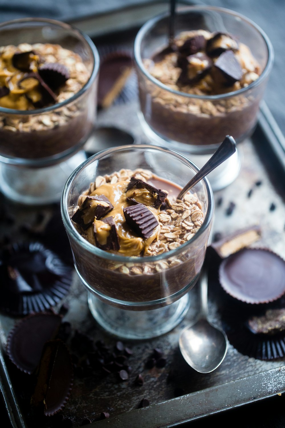 three clear low-stem glasses with chocolate desert foods