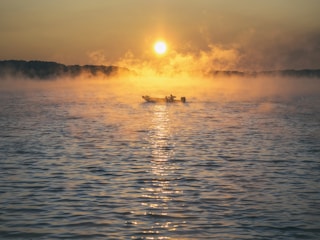 brown boat on calm body of water