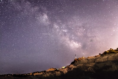 person standing on rock formation under starry sky maine google meet background