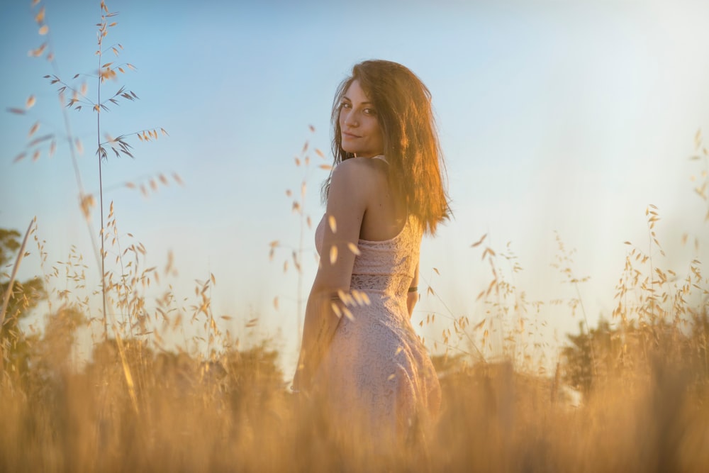 woman standing in the middle of brown grass