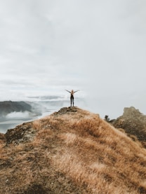 woman standing on top of hill