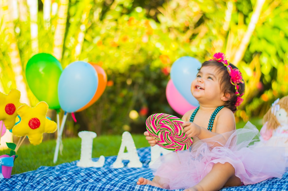 toddler looking up while holding candycane in party