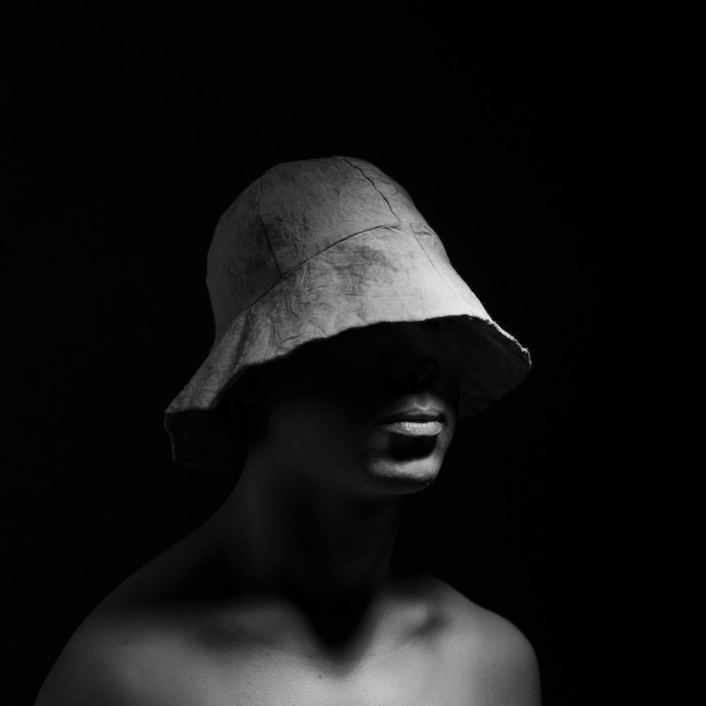 grayscale photo of topless man wearing bucket hat