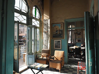 A bright, sunlit room with a calendar and clock showing opening hours.