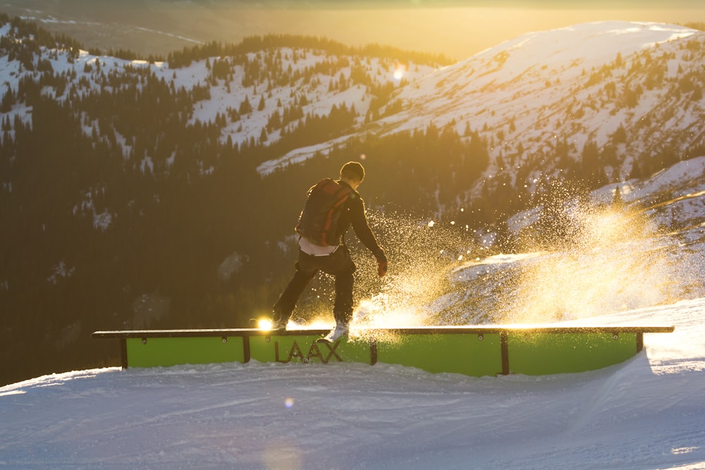 昼間、山の近くの手すりにスキーで乗る男