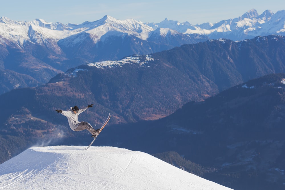 pessoa em camisa branca de manga comprida esquiando durante o dia