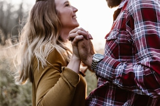 Best and Noon holding hands, smiling warmly against a backdrop of blush-toned decorations.