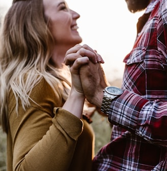 woman in front of man holding each hands each other near green trees