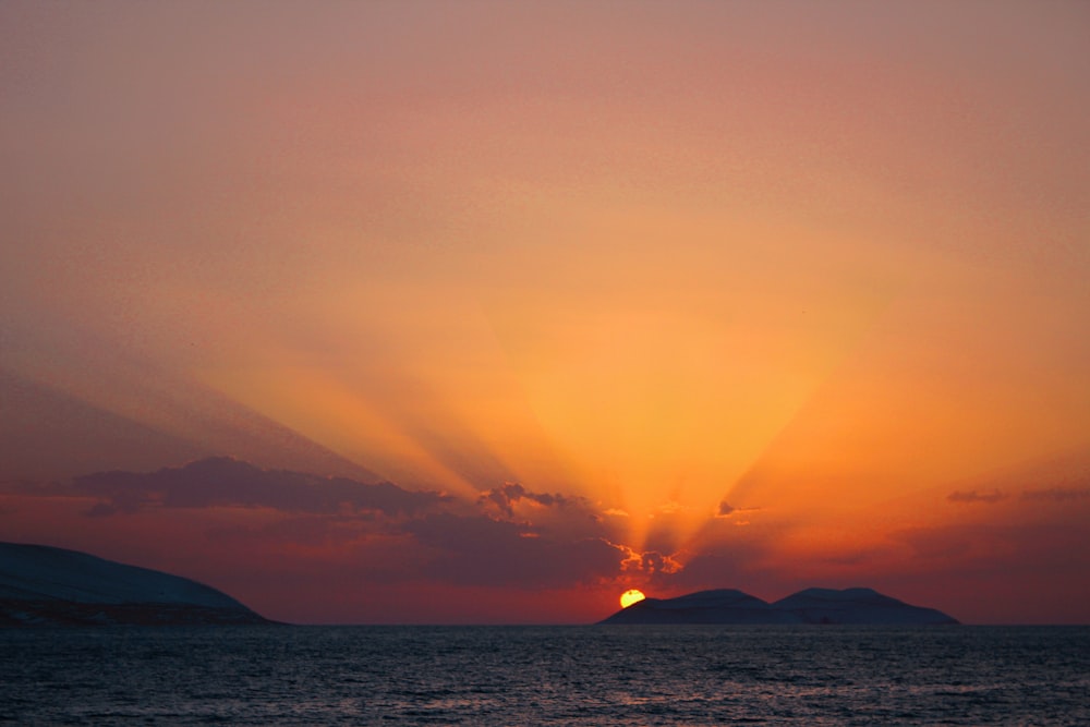 silhouette of mountain surrounded by sea