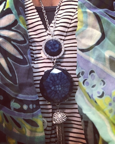 A vibrant scarf elegantly draped over a shoulder, complemented by a coordinating statement necklace.