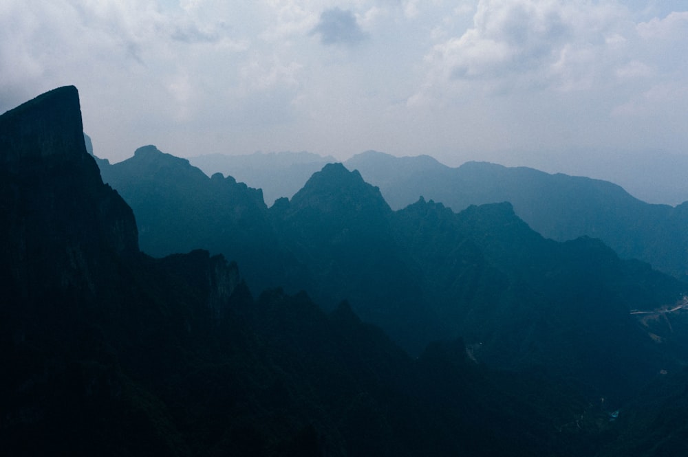 silhouette of mountains under cloudy sky