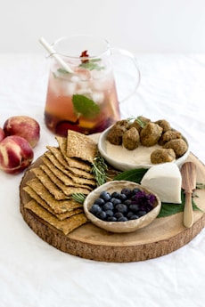 assorted-cook foods on round brown wooden tray