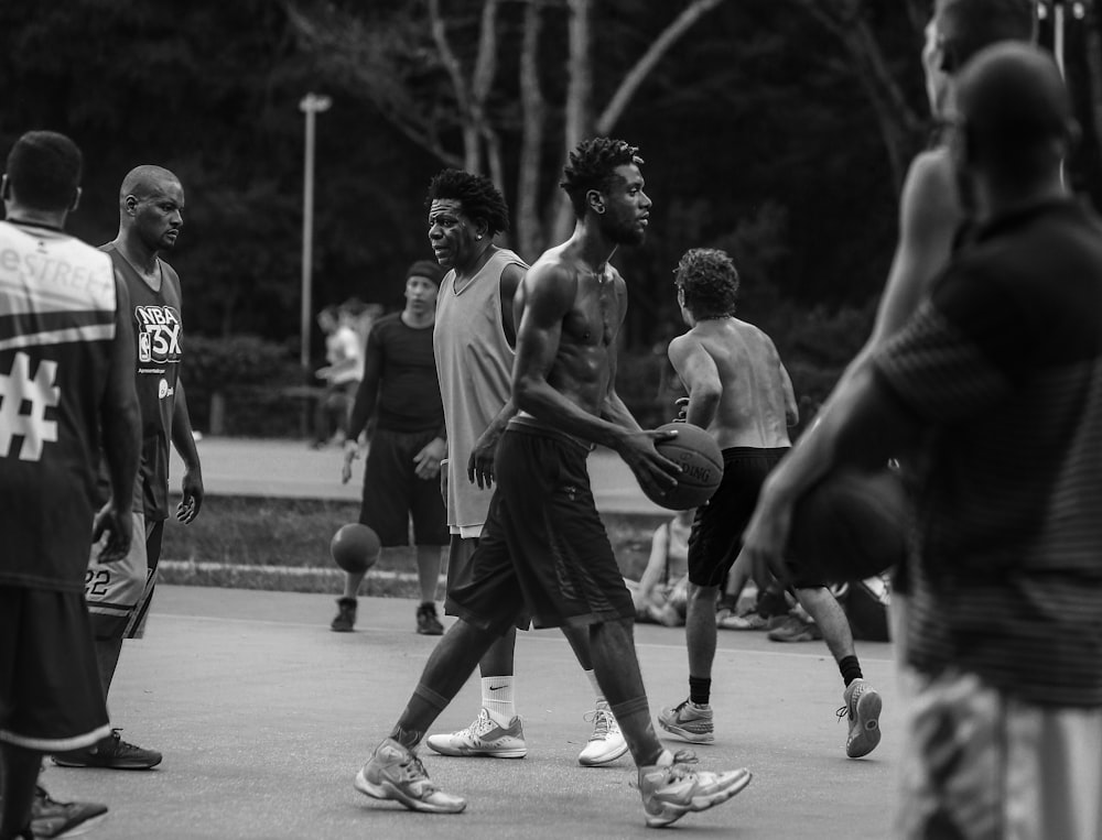 foto em tons de cinza de pessoas jogando basquete