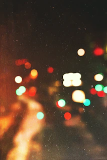 A moody, dark-themed background featuring blurred city lights reflecting a vibrant music vibe.