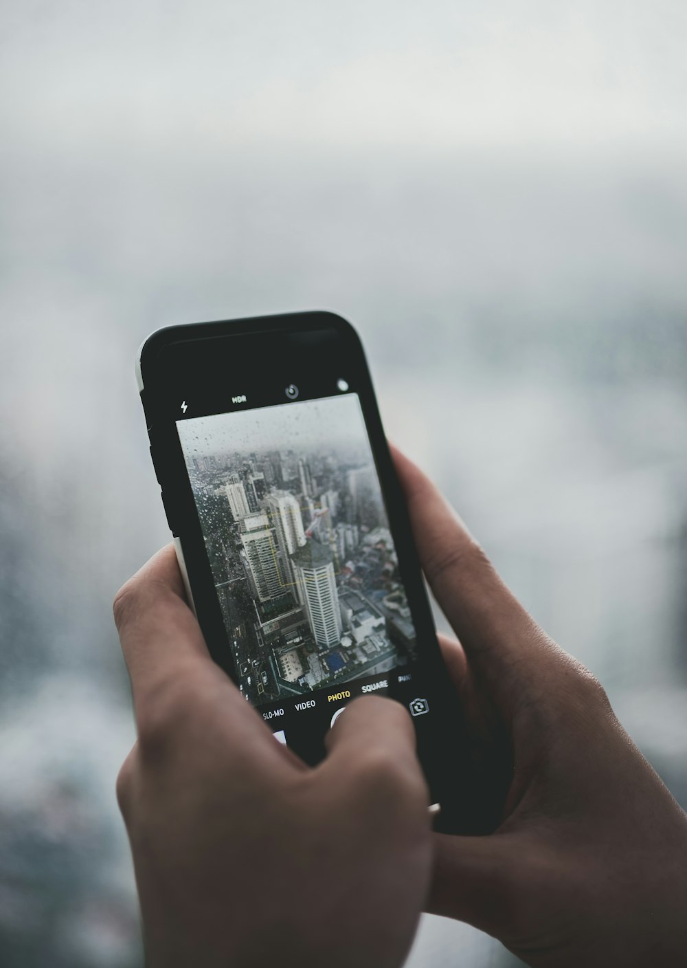 person holding black smartphone while taking photo of buildings