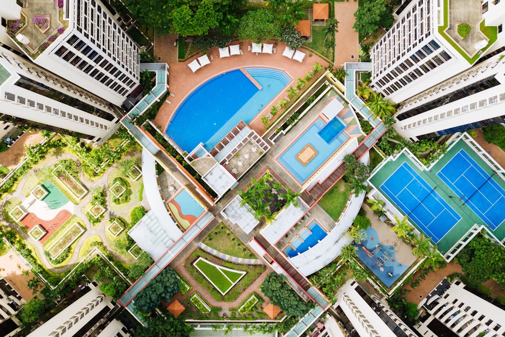 Fotografia com vista panorâmica de edifícios com piscinas e quadras de tênis