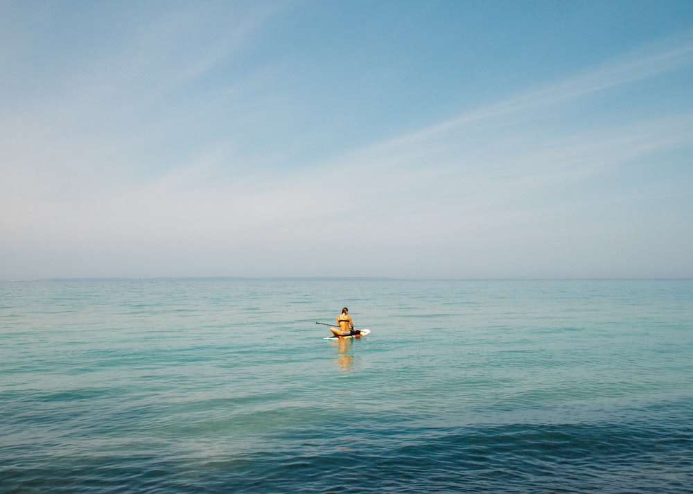 persona in mezzo allo specchio d'acqua durante il giorno