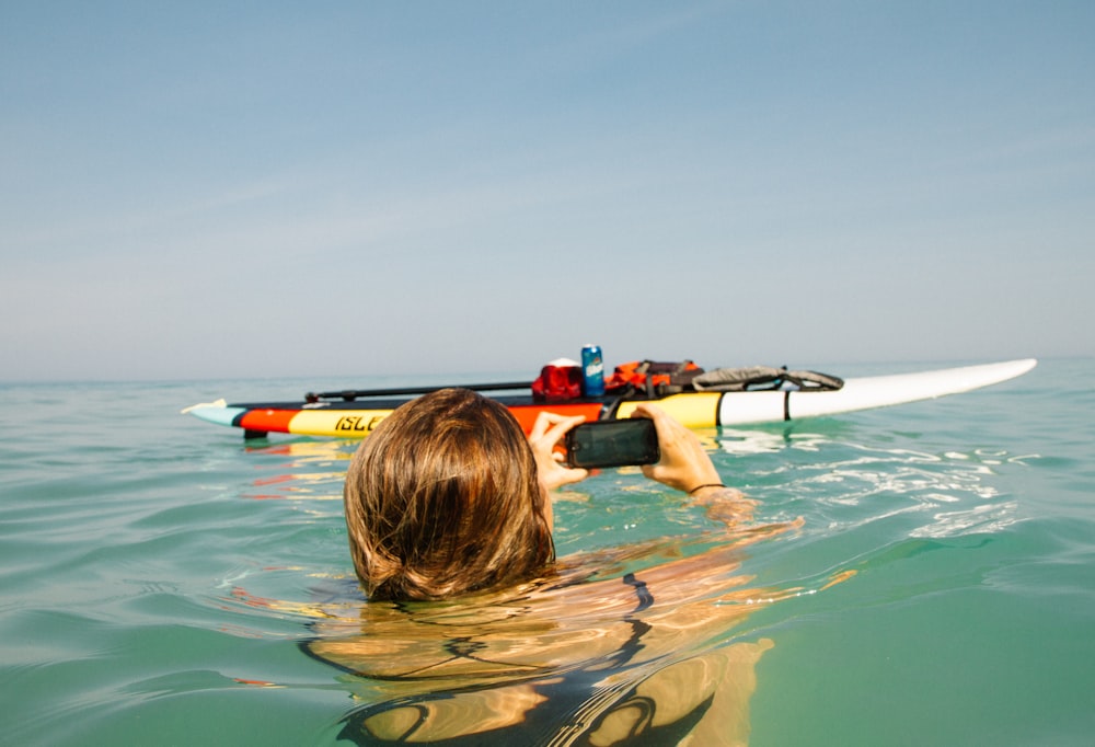 Person auf dem Wasser neben dem Paddelboot während des Tages