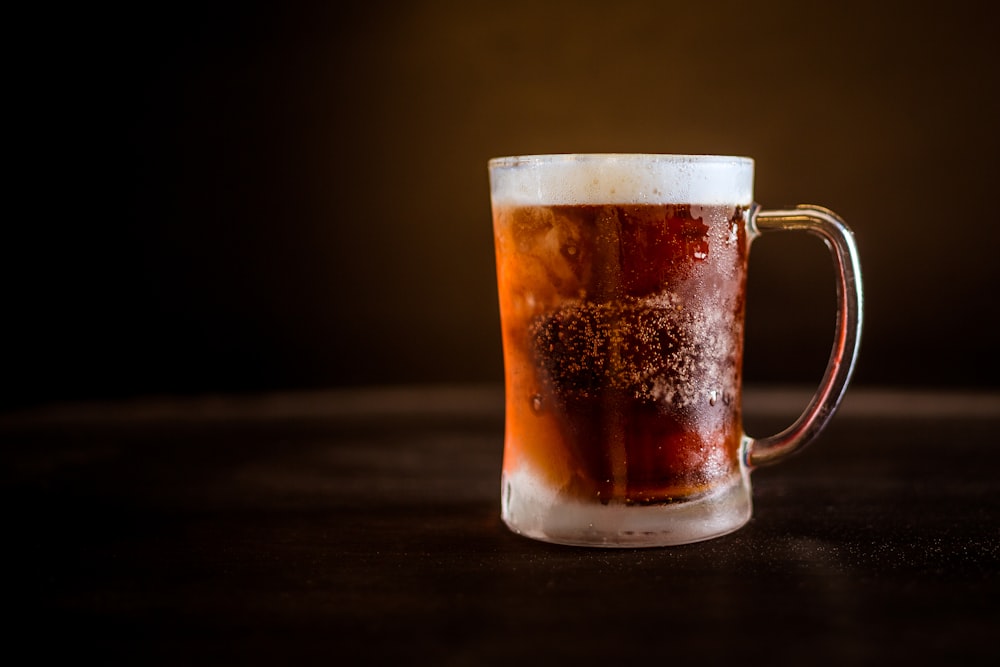 brown liquid on clear glass mug