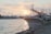 A serene fishing boat anchored near a calm coastal marina at sunset.