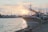 A serene fishing boat anchored near a calm coastal marina at sunset.