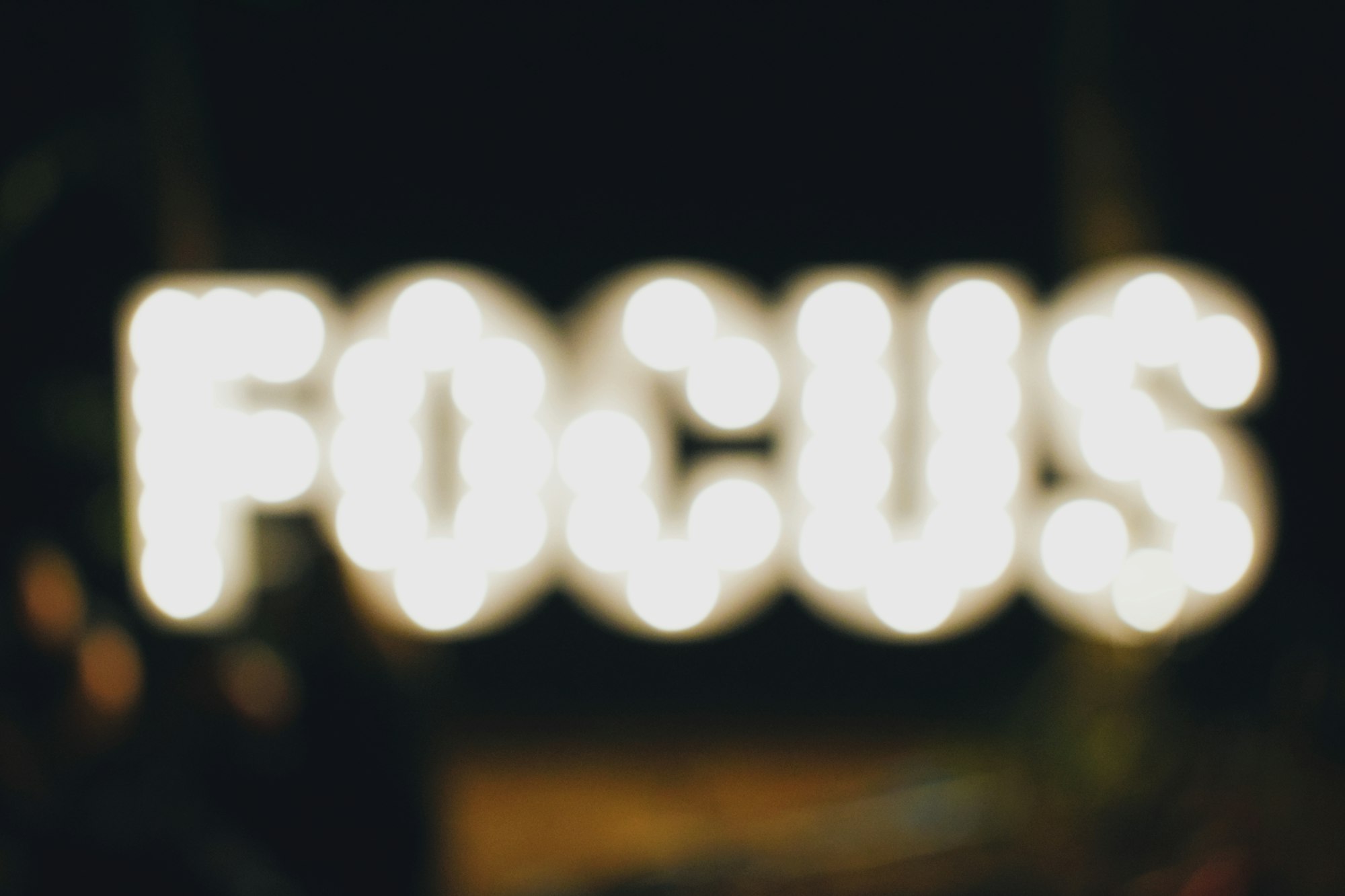 a blurry image of a lit sign reading "FOCUS"
