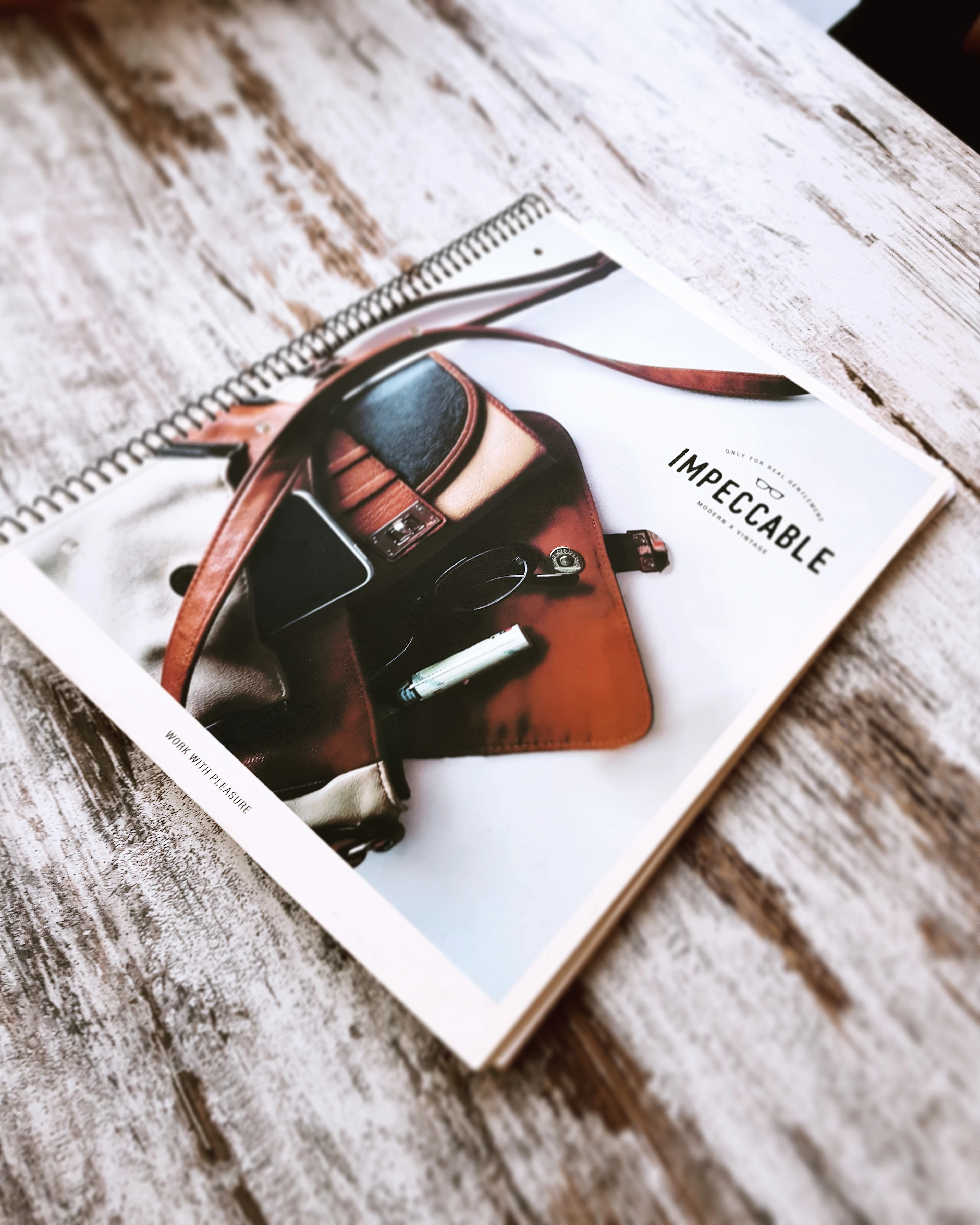 A clean blank notebook arranged on a wooden work surface