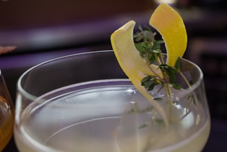 A close-up of a signature cocktail garnished with vibrant fruits and herbs.