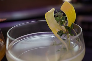 Close-up of a signature cocktail garnished with fresh herbs on a sleek bar counter.