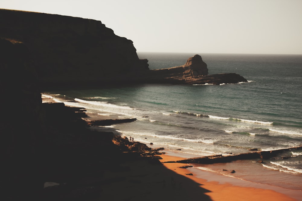 aerial photography of sea stack under gray sky