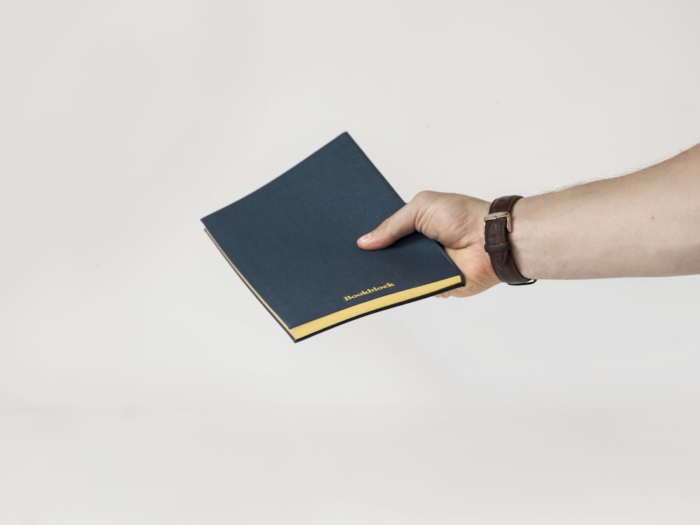 person holding blue book